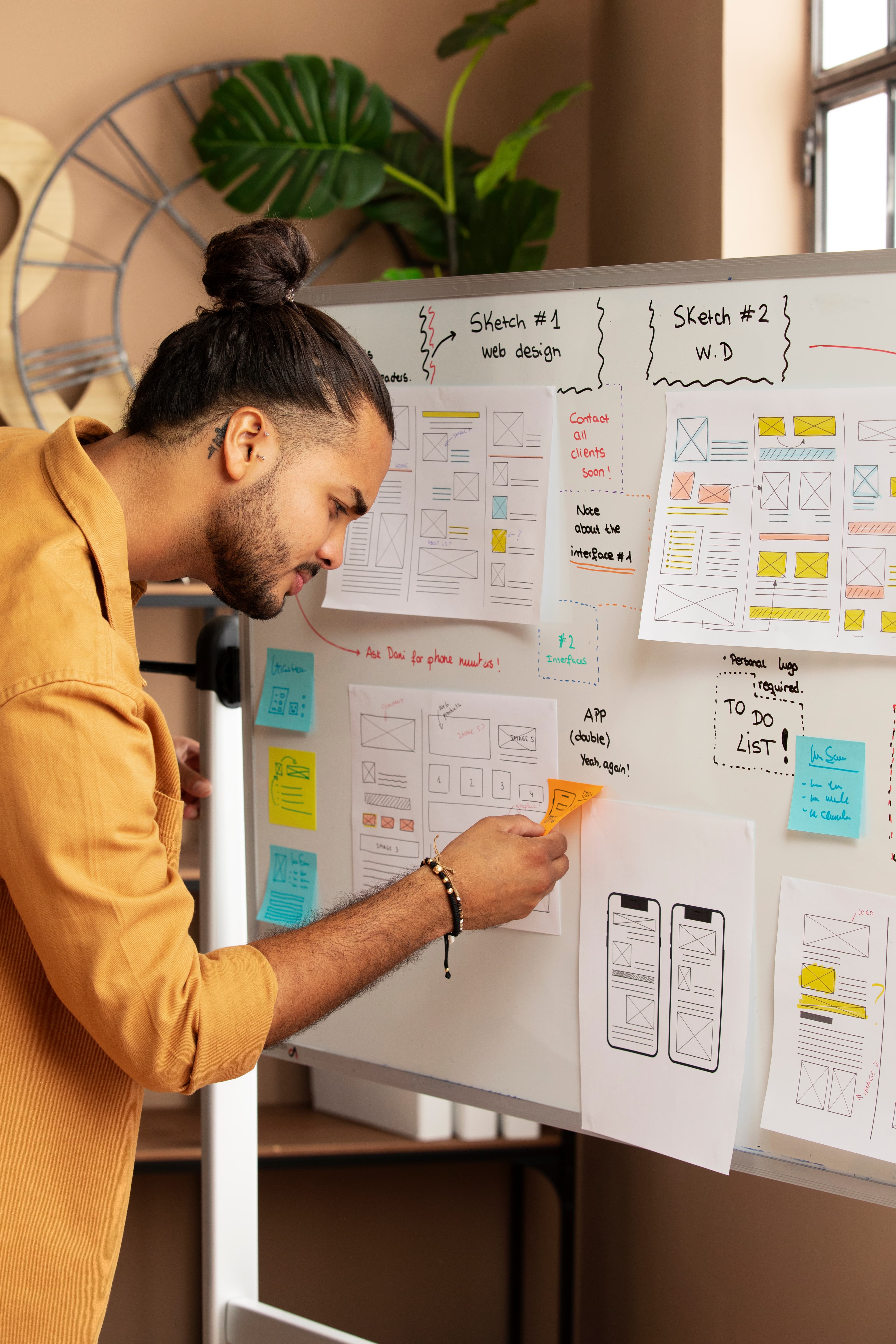 Designer arranging interface ideas on a whiteboard.